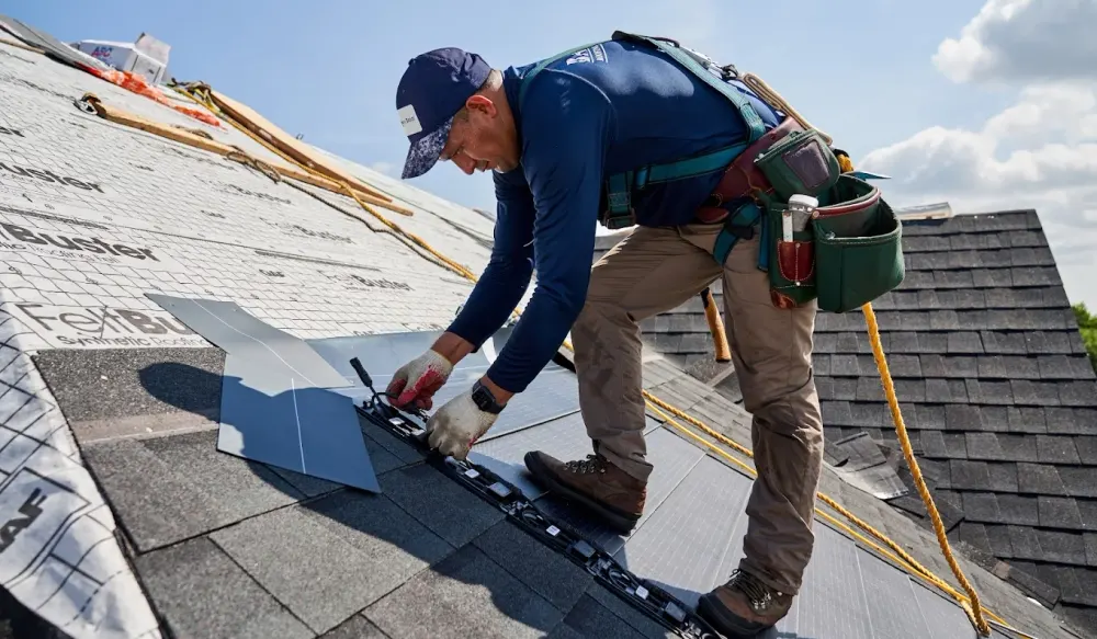 Roofer repairing shingles and fixing a leak